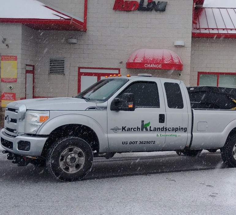 White commercial pickup truck parked in front of a brick building.